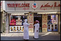 Men in front of jewellery, Gold Souk, Deira. United Arab Emirates ( color)