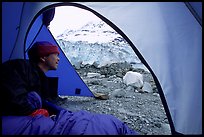 Visitor in  tent looking outside to Lamplugh Glacier. Glacier Bay National Park, Alaska (color)