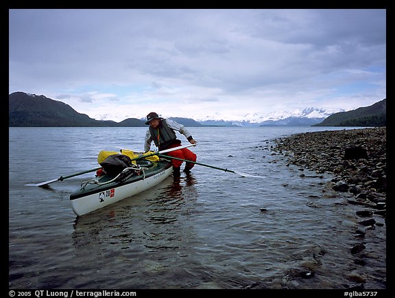 Kayaker getting into the kayak,  Muir Inlet. Glacier Bay National Park, Alaska
