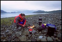 Kayaker firing up the stove,  Muir Inlet. Glacier Bay National Park, Alaska