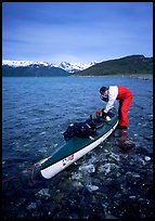 Kayaker tying up gear on top of the kayak,  East Arm. Glacier Bay National Park, Alaska ( color)