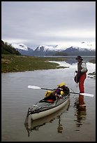 Kayaker standing in Scidmore Bay next to a shallow tidal channel. Glacier Bay National Park, Alaska