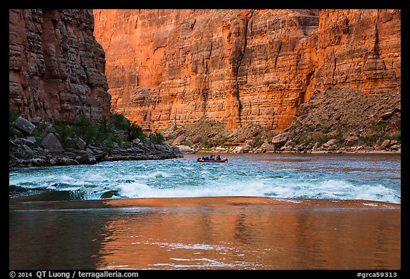 Glassy river, rapids and boat below Redwall canyon walls. Grand Canyon National Park, Arizona