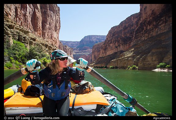 Woman rows raft on calm section of Colorado River, Marble Canyon. Grand Canyon National Park, Arizona