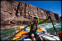 Woman stirring raft with oars in rapid. Grand Canyon National Park, Arizona