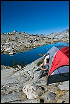 Man looking out from tent above lake, morning, Dusy Basin. Kings Canyon National Park, California (color)