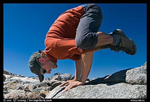 Hiker balancing on hands on rock, Bishop Pass. Kings Canyon National Park, California