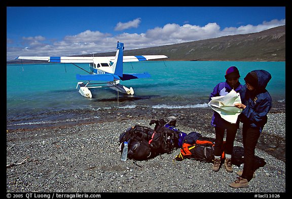 Backpackers dropped off by floatplane on Lake Turquoise orient themselves on the map. Lake Clark National Park, Alaska (color)