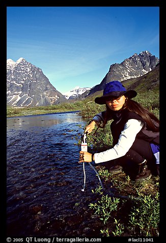 Woman filtering water from a stream. Lake Clark National Park, Alaska