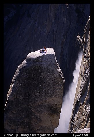 Climber resting on top of Lost Arrow spire with Yosemite Falls behind. Yosemite National Park, California (color)