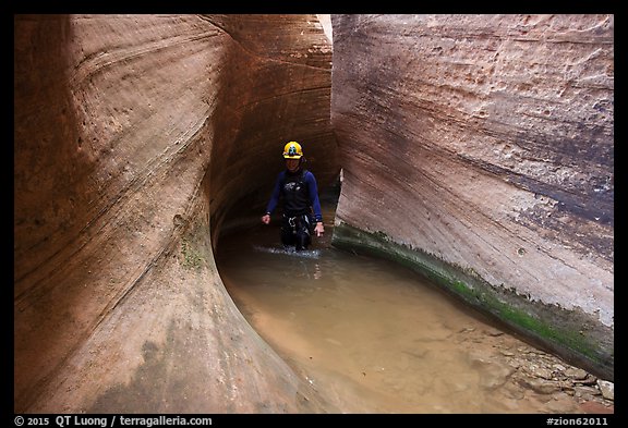 Hiker walks in water in Keyhole Canyon. Zion National Park, Utah (color)