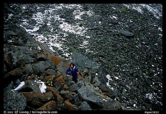 Backpacker in boulder field at the base of the Arrigetch Peaks. Gates of the Arctic National Park, Alaska (color)