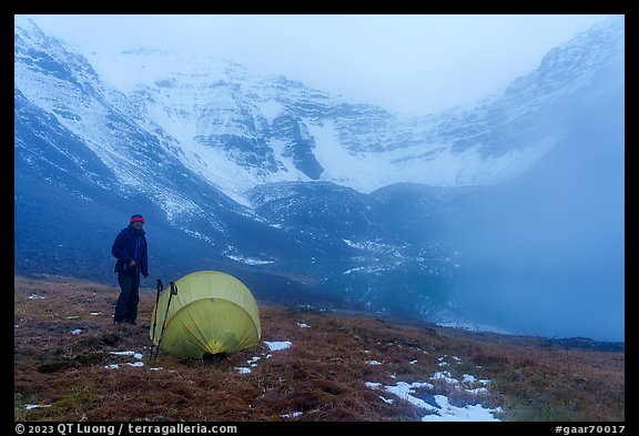 Camper standing by tent with fog approaching. Gates of the Arctic National Park (color)