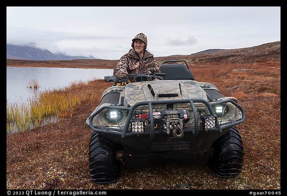 Nunamiut man driving all-terrain vehicle. Gates of the Arctic National Park (color)
