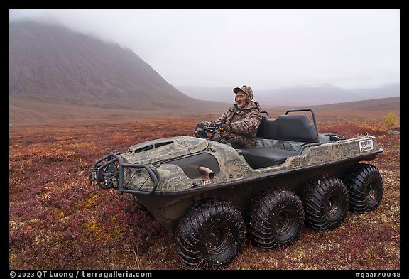 Nunamiut man driving eight-wheeled all-terrain vehicle. Gates of the Arctic National Park (color)