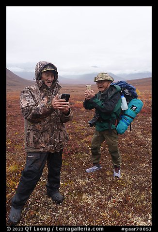 Nunamiut man and visiting backpacker with cell phones. Gates of the Arctic National Park (color)