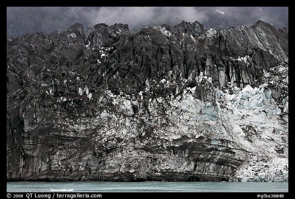 Ice colored by black moraining debris on the front of Margerie Glacier. Glacier Bay National Park, Alaska, USA.