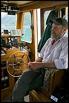 Captain sitting at the wheel. Glacier Bay National Park, Alaska, USA.
