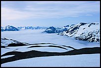 Dark bands of freshly uncovered terrain, snow, and low clouds, dusk. Kenai Fjords National Park, Alaska, USA. (color)