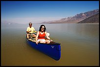 Canoists in rarely formed Manly Lake with Black Mountains in the background. Death Valley National Park, California, USA.