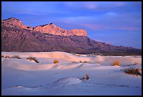 White gyspum sand dunes and cliffs of Guadalupe range at dusk. Guadalupe Mountains National Park, Texas, USA.