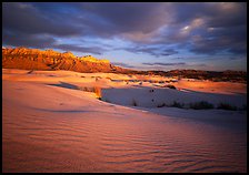 Red light of sunset on white sand dunes and Guadalupe range. Guadalupe Mountains National Park, Texas, USA.