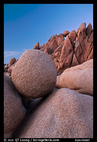 Spherical granite boulder and angular rocks, twilight. Joshua Tree National Park, California, USA.