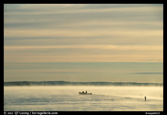 Boaters in fog, early morning, Kabetogama Lake. Voyageurs National Park, Minnesota, USA.