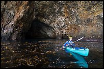 Kayaker paddling out of sea cave, Santa Cruz Island. Channel Islands National Park ( color)