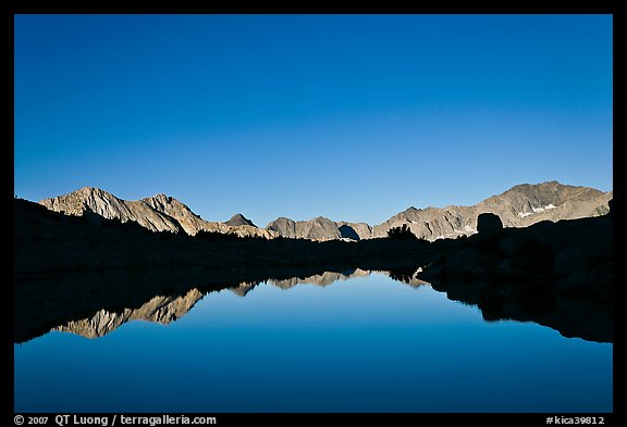 Mountain range reflected in calm lake, Dusy Basin. Kings Canyon National Park, California, USA.