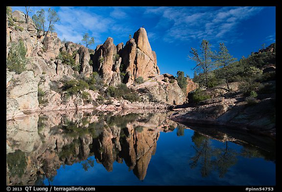 Spire and reflection in glassy water, Bear Gulch Reservoir. Pinnacles National Park, California, USA.