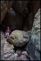 Man with headlamp looking up in Balconies Cave. Pinnacles National Park, California, USA. (color)