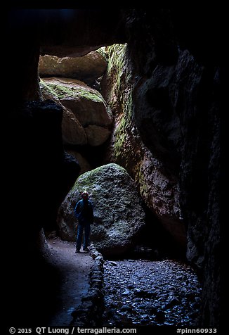 Hiker with headlamp in Bear Gulch Cave. Pinnacles National Park (color)