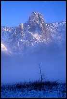 Sentinel Rock rises above the fog of the Valley floor in winter. Yosemite National Park, California, USA.