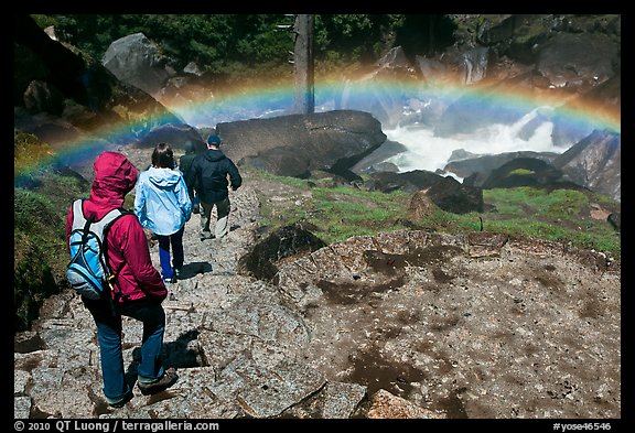 Hikers walking through rainbow, Mist Trail. Yosemite National Park, California, USA.
