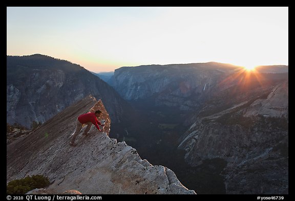 Hiker looking over the edge of the Diving Board, sunset. Yosemite National Park, California, USA.