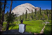 Hiker looking at backside of Half-Dome from Lost Lake. Yosemite National Park, California, USA. (color)