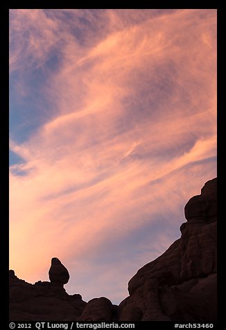 Sunset clouds and small balanced rock. Arches National Park, Utah, USA.