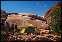 Tent with prayer flags amongst sandstone rocks. Arches National Park, Utah, USA.
