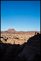 Hiker standing in silhouette above the Maze. Canyonlands National Park, Utah, USA.