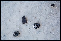 Dark rock on soil with fine cracks. Badlands National Park, South Dakota, USA.
