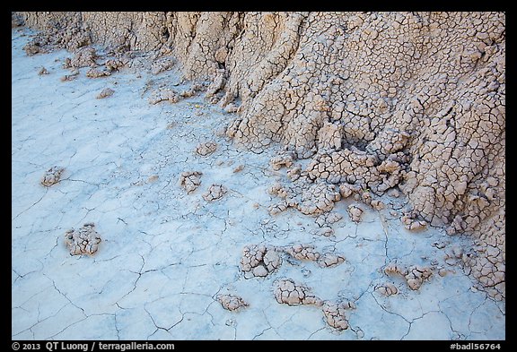 Base of butte with mudstone rolling onto flat soil. Badlands National Park, South Dakota, USA.