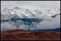 Snowy Sangre de Cristo Mountains and clouds above dune field. Great Sand Dunes National Park and Preserve, Colorado, USA.