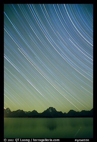 Star trails on Teton range above Jackson lake, dusk. Grand Teton National Park, Wyoming, USA.