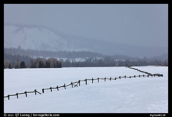 Wooden fence, snow-covered flat, hills in winter. Grand Teton National Park, Wyoming, USA.