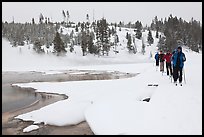 Cross country skiers pass Chromatic Spring. Yellowstone National Park, Wyoming, USA. (color)