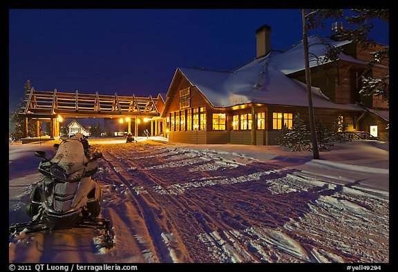 Snowmobiles parked next to Old Faithful Snow Lodge at night. Yellowstone National Park, Wyoming, USA.