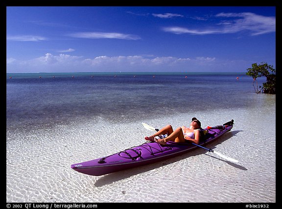 Woman reclining in kayak on shallow waters,  Elliott Key. Biscayne National Park, Florida, USA.