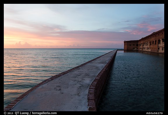 Fort Jefferson moat and walls at sunset with tourists in distance. Dry Tortugas National Park, Florida, USA.