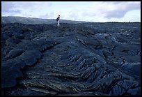 Hiker on hardened lava flow at the end of Chain of Craters road. Hawaii Volcanoes National Park, Hawaii, USA. (color)